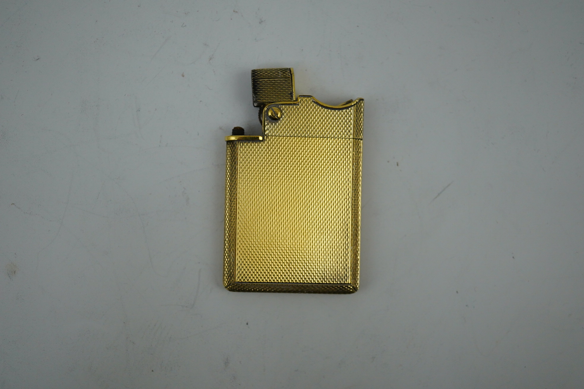 An Elizabeth II Asprey & Co engine turned silver gilt 'wafer' lighter